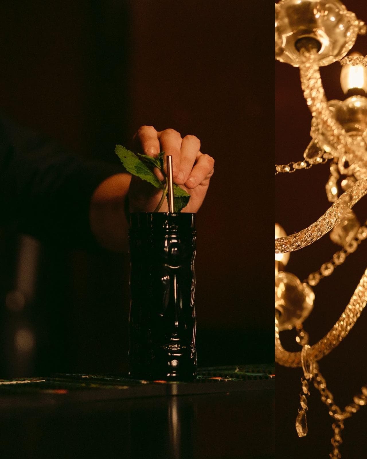 Main déposant une paille et de la menthe dans un verre tiki noir