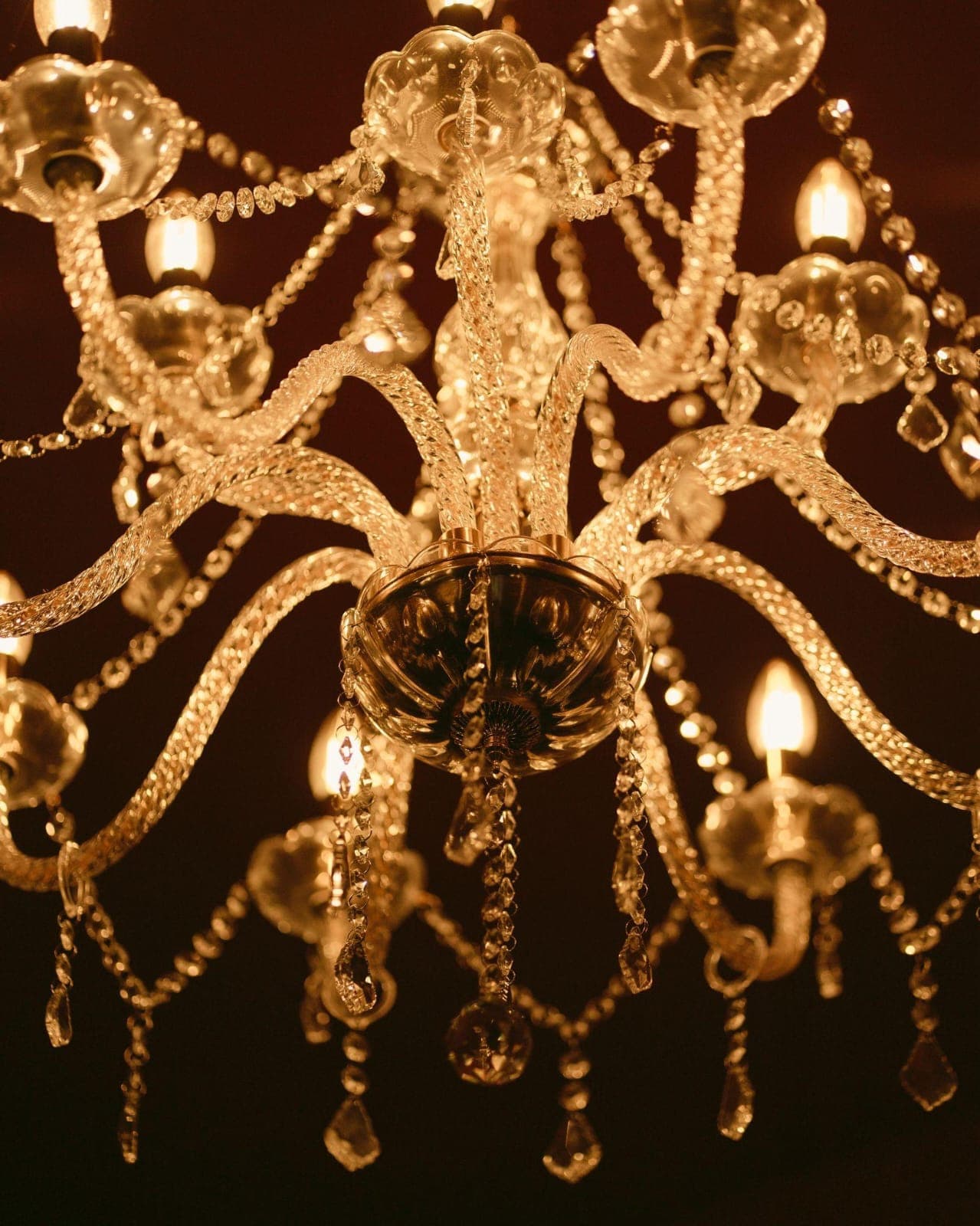 Gros plan sur un lustre en cristal aux pampilles allumées